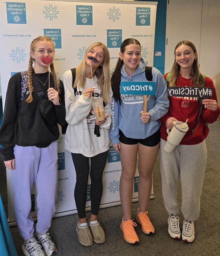 Female students, smiling with selfie props, wearing sweatshirts